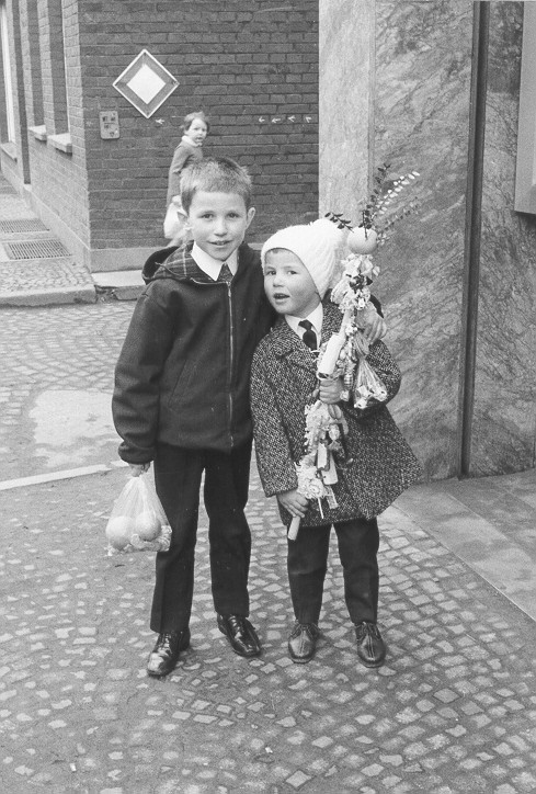 Zwei Jungen, einer mit einem Plastikbeutel, einer mit einem Palmstock.