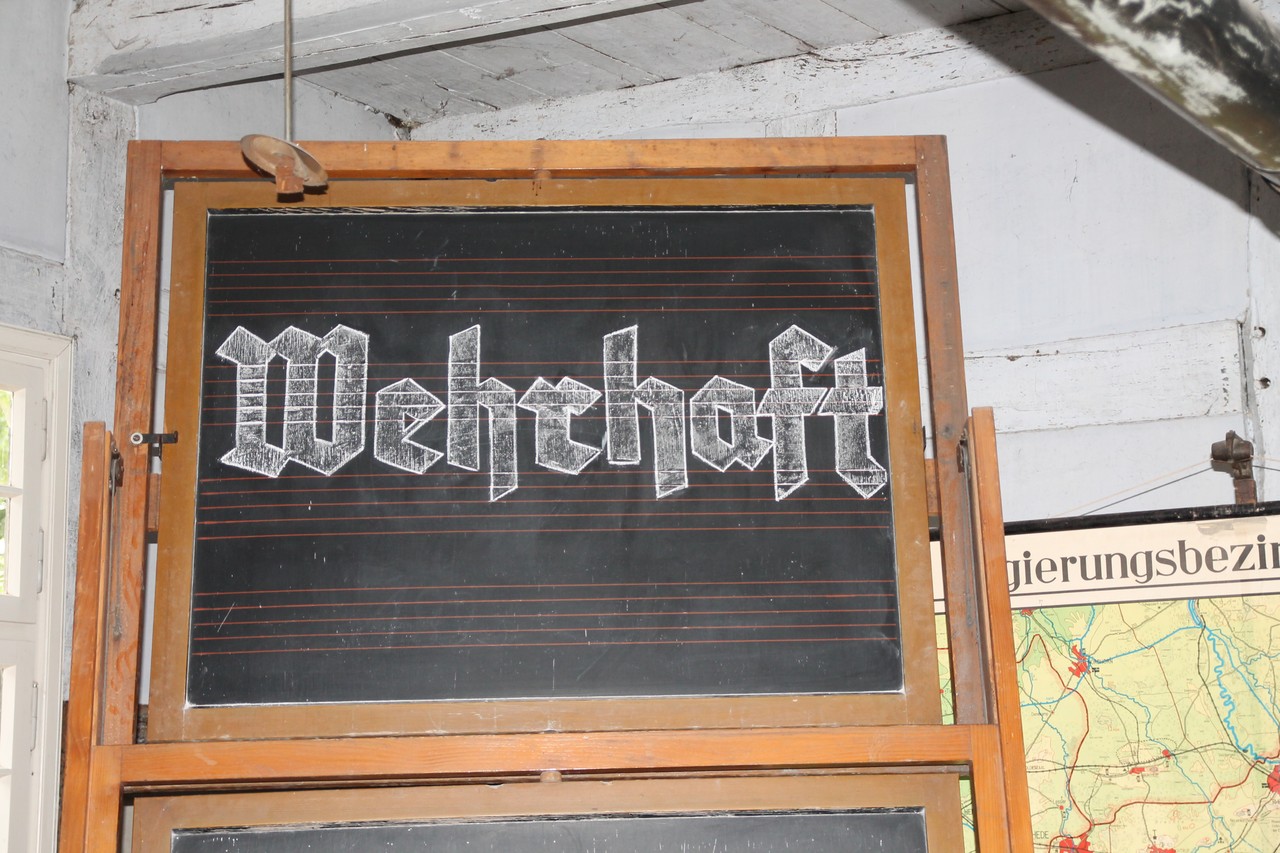 Eine Auseinandersetzung darüber, wer oder was in einer Dorfschule wehrhaft sein oder werden soll, fordert die Arbeit von Mira Reeh ein. (Foto: Christiane Cantauw)