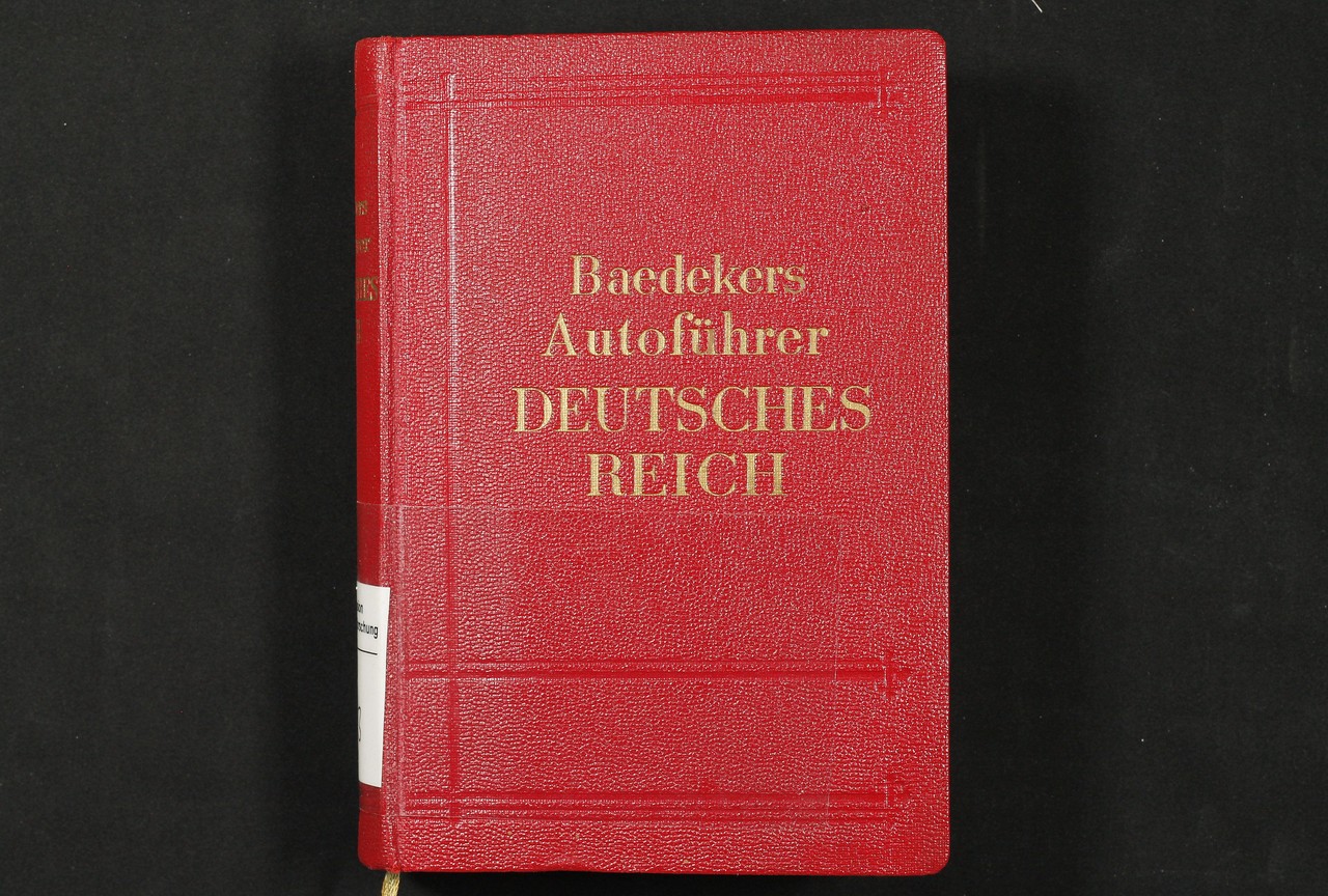 Mit dem Autoführer, der mit seinem roten Kunstledereinband mit goldener Prägeschrift dem bereits eingeführten Erscheinungsbild der Baedeker-Reiseführer entsprach, wandte sich der Baedeker-Verlag erstmals einer neuen Reiseform, dem Autoreisen, zu. (Foto: Kommission Alltagskulturforschung)