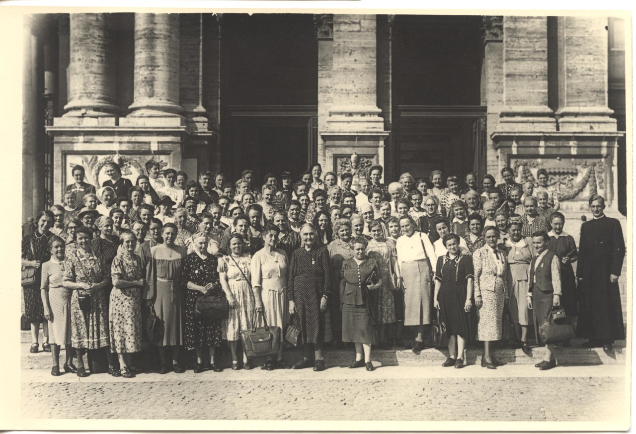 Teilnehmerinnen am Pilgerzug nach Rom im Heiligen Jahr 1950. Bei dem Priester in Soutane ganz rechts im Bild handelt es sich vermutlich um einen vom dt. Pilgerbüro vermittelten Fremdenführer (Bestand Kruse, LWL-Alltagskulturarchiv).