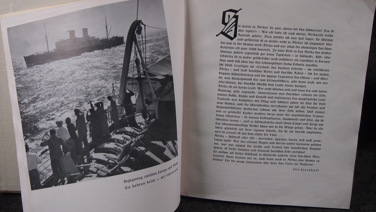 Ein aufgeschlagenes Buch, auf der linken Seite ist ein Foto eines Schiffes, auf der rechten Seite Text.