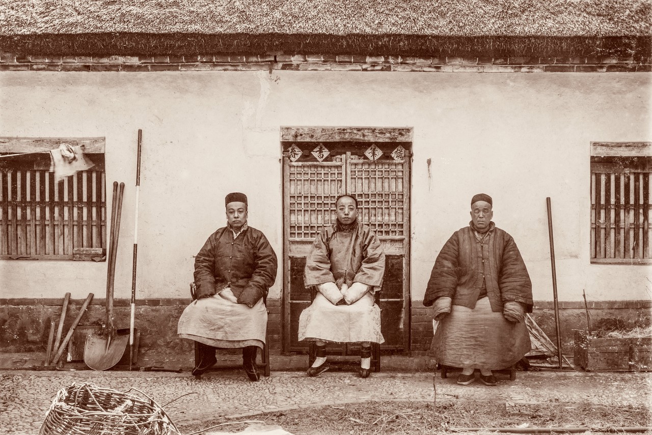 Gruppenporträt wohlhabender Bauern aus der Provinz Schantung, links im Bild Grabwerkzeug und Vermessungsstab. Aus dem China-Album des Hugo von Königslöw 1898/1901, Foto: Bergassessor Hugo von Königslöw