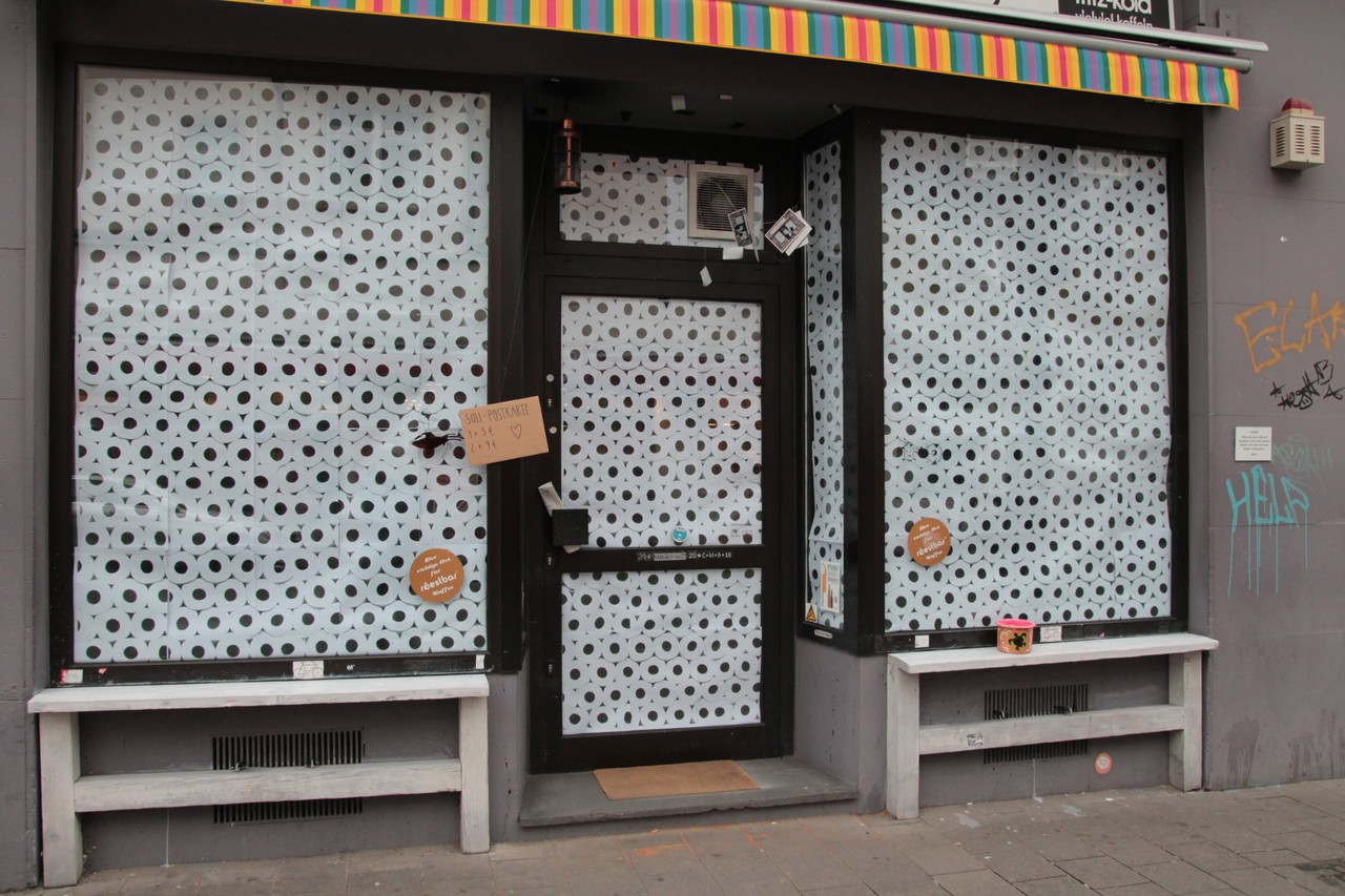 Ein Geschäft, dessen Fenster mit Toilettenpapier dekoriert sind.