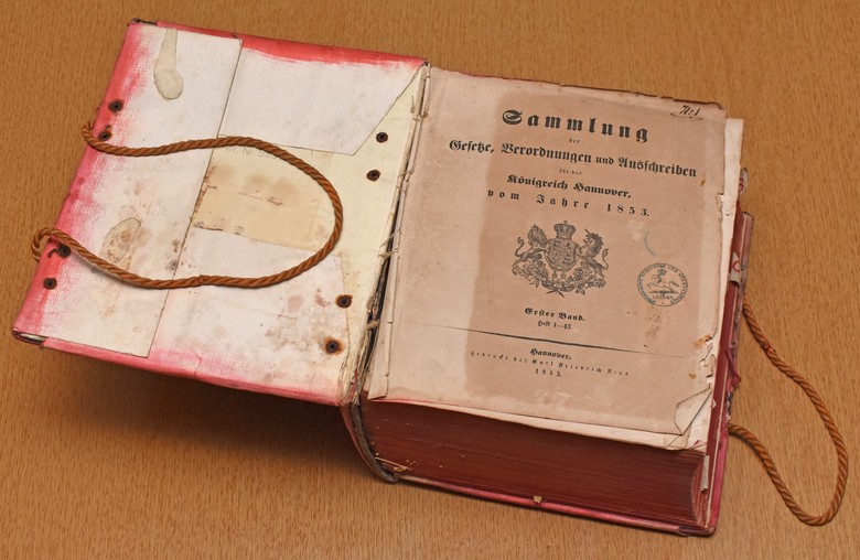 Das Buch des Nikolaus, aufgeschlagen. Auf dem Deckblatt steht: "Sammlung der Gesetze, Verordnungen und Anschreiben für das Königreich Hannover vom Jahre 1853". Foto: Andreas Eiynck.