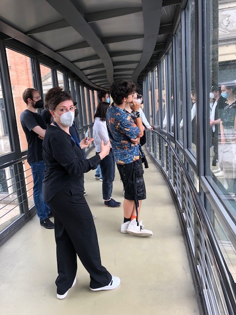 Auf der Glasbrücke, die vom historischen Museumsbau des Überseemuseums zum Neubau „Übermaxx“ führt, der das Magazin beherbergt, erklärt Bettina von Briskorn einige der meterhohen Steintafeln in den Außenmauern des 1896 eröffneten Museums, auf denen die Reichtümer der deutschen Kolonien im Bild gepriesen werden.