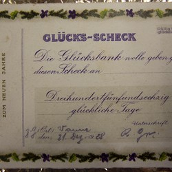 Auch der Glücks-Scheck, der auf den 31. Dezember 1928 datiert ist, knüpft an die Verbindung von Geld und Glück an, wendet diese aber ins Symbolische, indem ein Scheckformular nur angedeutet und durch Jahresend- und Glückssymbole und die besondere Betonung des Glücks ergänzt wird. Foto: Christiane Cantauw, KAF. (vergrößerte Bildansicht wird geöffnet)