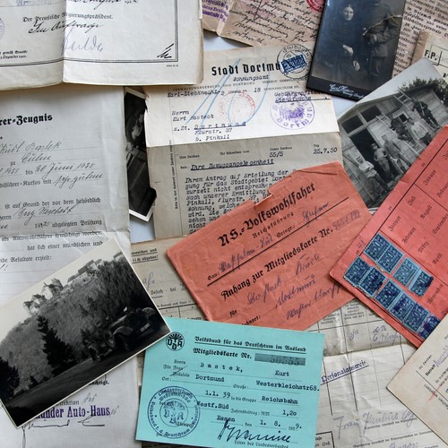 Verschiedene Dokumente und Fotos aus dem Nachlass einer Familie liegen durcheinander auf einer Fläche.