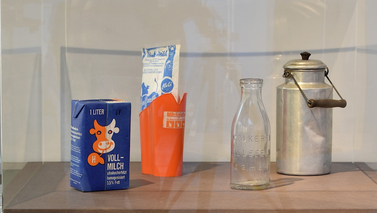 Milchkanne – 1920er bis 1940er Jahre, Milchflasche aus Glas – 1950/60er Jahre, Milchschlauch und Milchausgießer – 1960er Jahre, Tetra Pak –1980er Jahre, Foto: Historisches Museum Bielefeld.