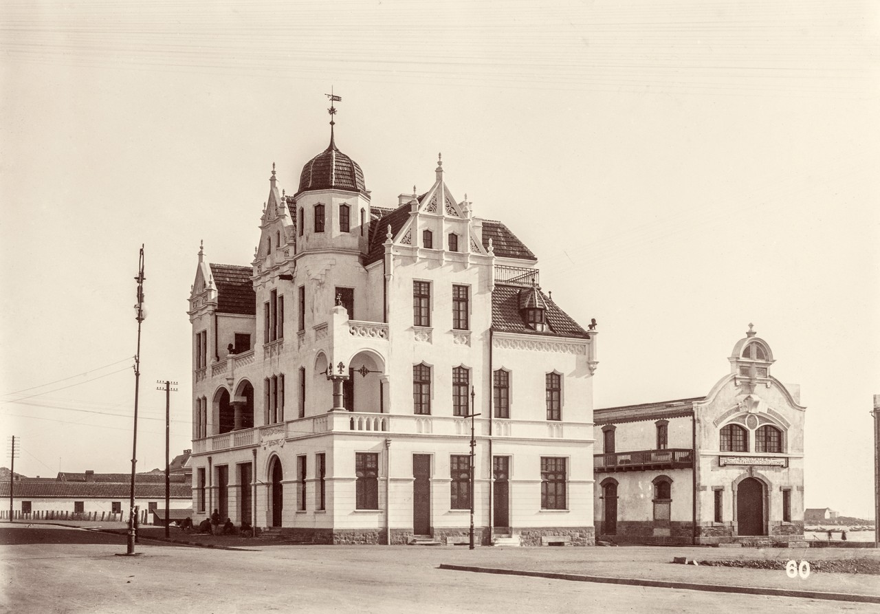 Professionelle Fotografie aus der kolonialen „Stadt vom Reißbrett“ Tsingtau. Besonders die technische Qualität und der Motiv-Zähler unten rechts im Bild, weisen das Motiv als professionelle Aufnahme aus. Zu sehen sind das Geschäftshaus der Gebrüder Bodeweg, Prinz-Heinrich-Straße, rechts daneben die Tsingtauer Industrie- und Handels-Gesellschaft, Tsingtau. Aus dem China-Album des Hugo von Königslöw 1898/1901, Foto: Dr. Friedrich Behme