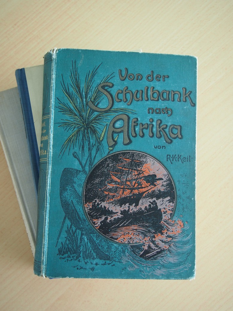 In den 1890er Jahren mehrten sich die Publikationen über die Kolonien. Von Abenteuerbüchern bis hin zu Autobiografien und Sachbüchern popularisierten sie den Kolonialismus. Die meist eurozentristischen Darstellungen wie das 1897 erschienene „Von der Schulbank nach Afrika“ legten ihren Leser:innen nahe, dass im fernen Afrika spannende Erlebnisse und Erfahrungen auf sie warteten. (Foto: Cantauw)