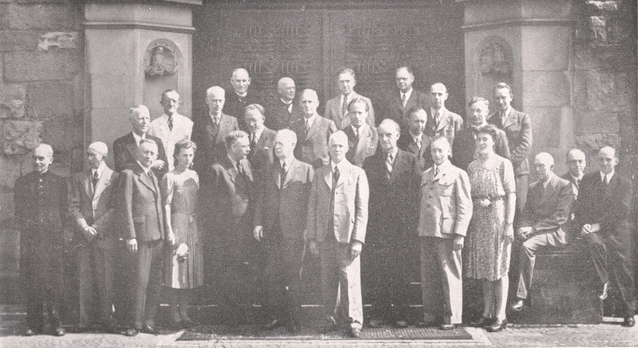 Lehrerkollegium des Gymnasiums Dionysianum im Juli 1948, die beiden Studienassessorinnen Frau Dr. Krakhecke und Frau Dr. Elfert stehen in der ersten Reihe als vierte von rechts und links (Repro: Komm. Alltagskulturforschung, aus Hermann Rosenstengel, Kriegschronik …, Anhang).