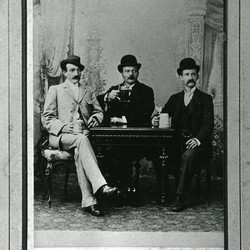 Drei Biertrinker an einem Tisch, fotografiert in einem Atelier. (vergrößerte Bildansicht wird geöffnet)