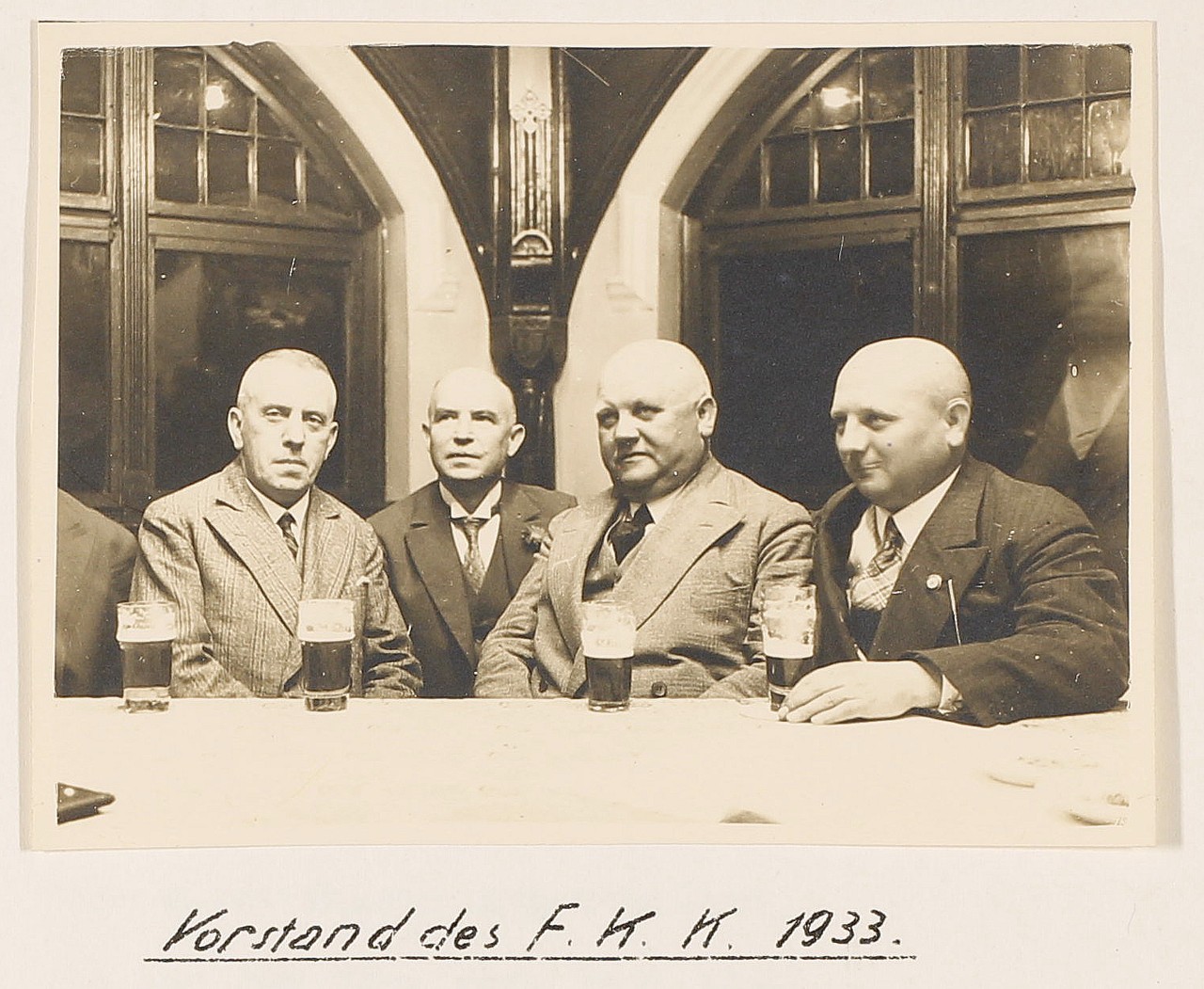Der Vereinsvorstand 1933 hinter Biergläsern.